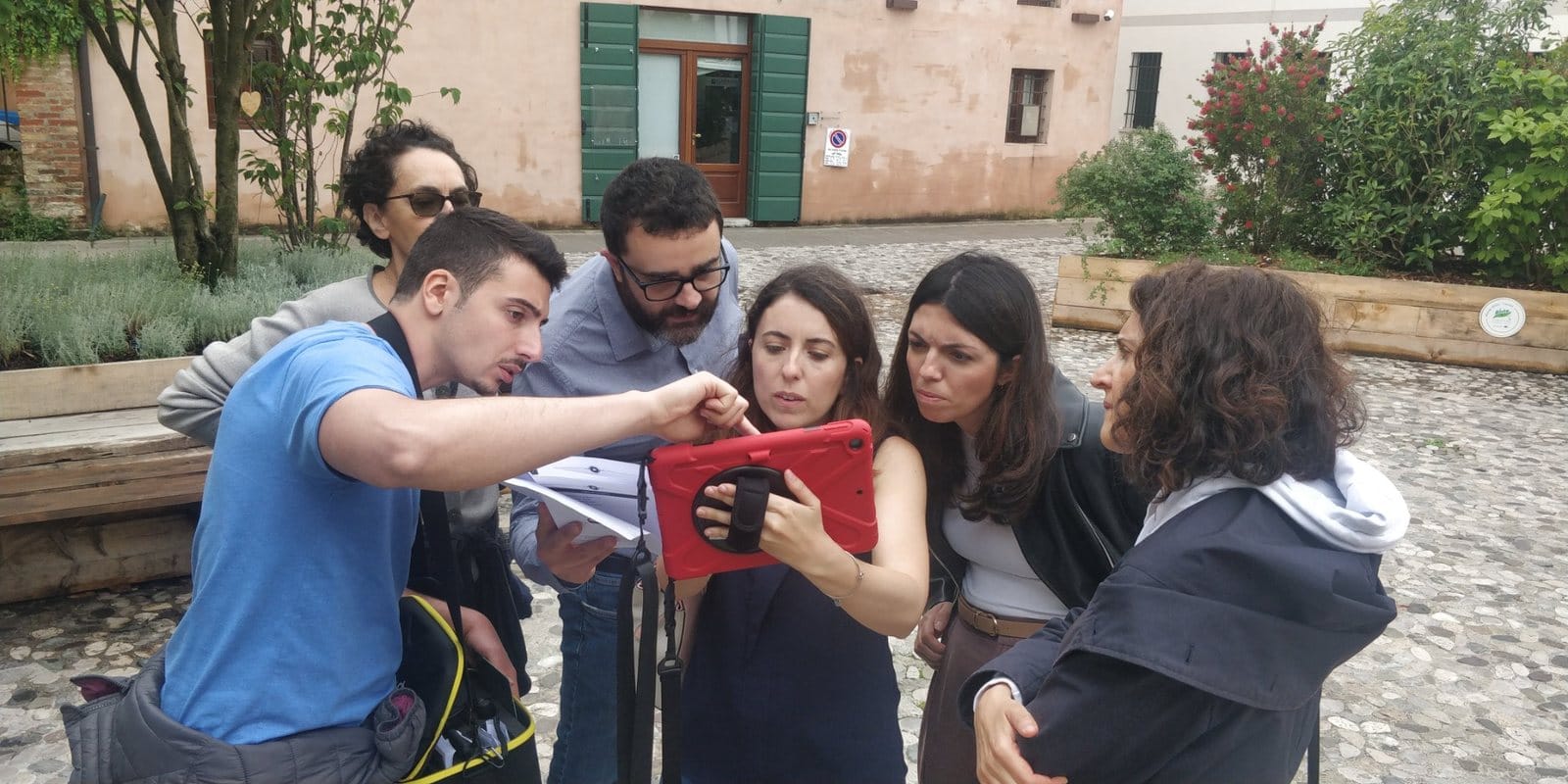 Team aziendale che collabora davanti a un tablet durante un City Game a Treviso
